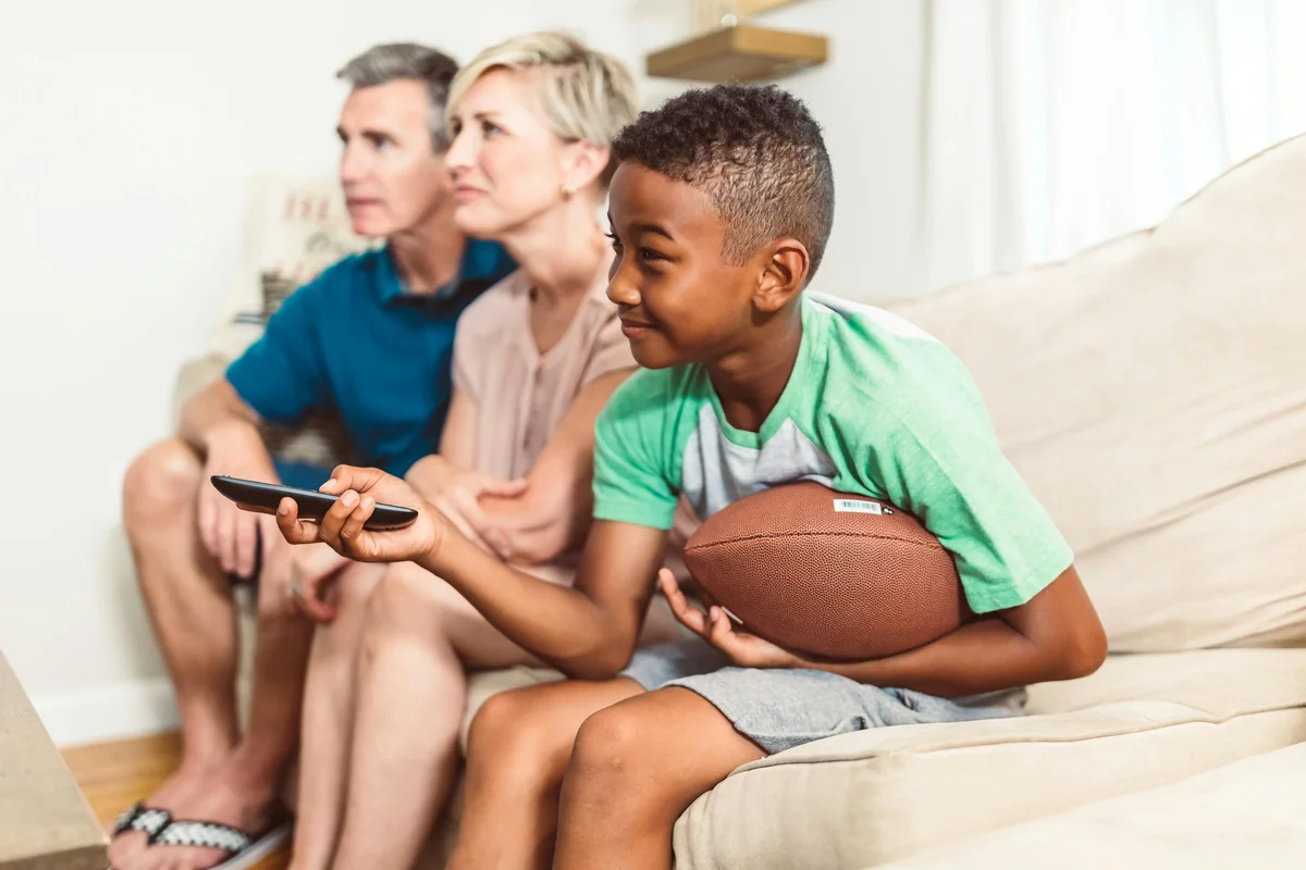 Familj streamar tillsammans i vardagsrummet