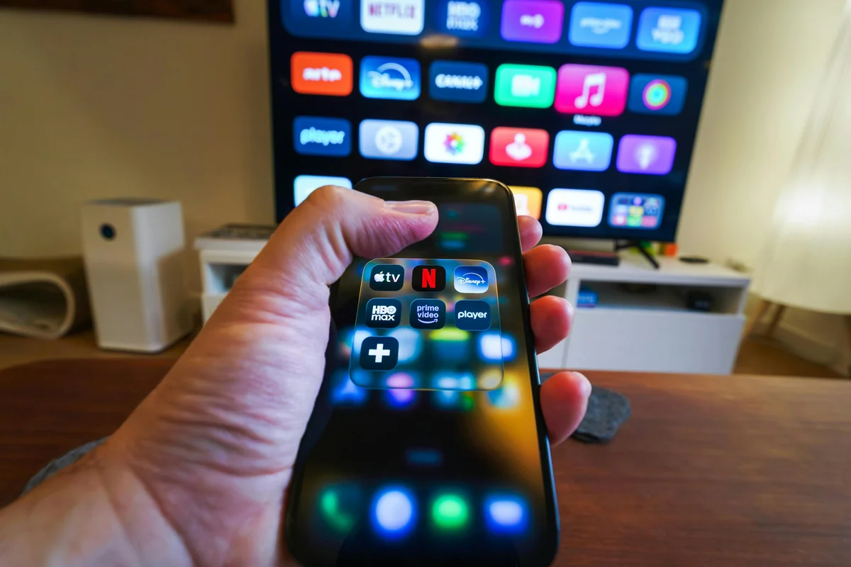 Man holding TV remote control while navigating Fire TV settings