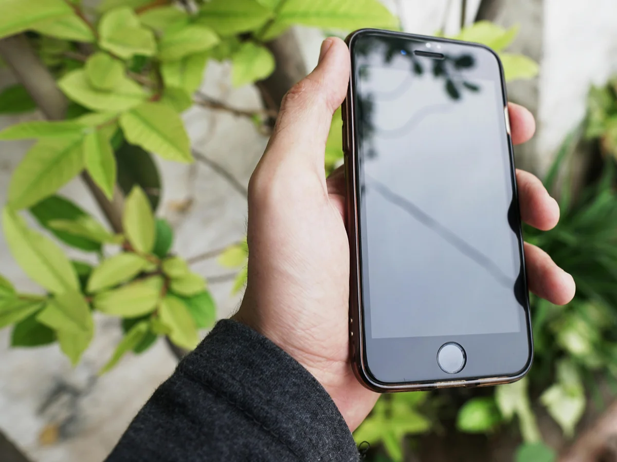 iPhone user watching IPTV on the couch — cord cutting with IPTV One