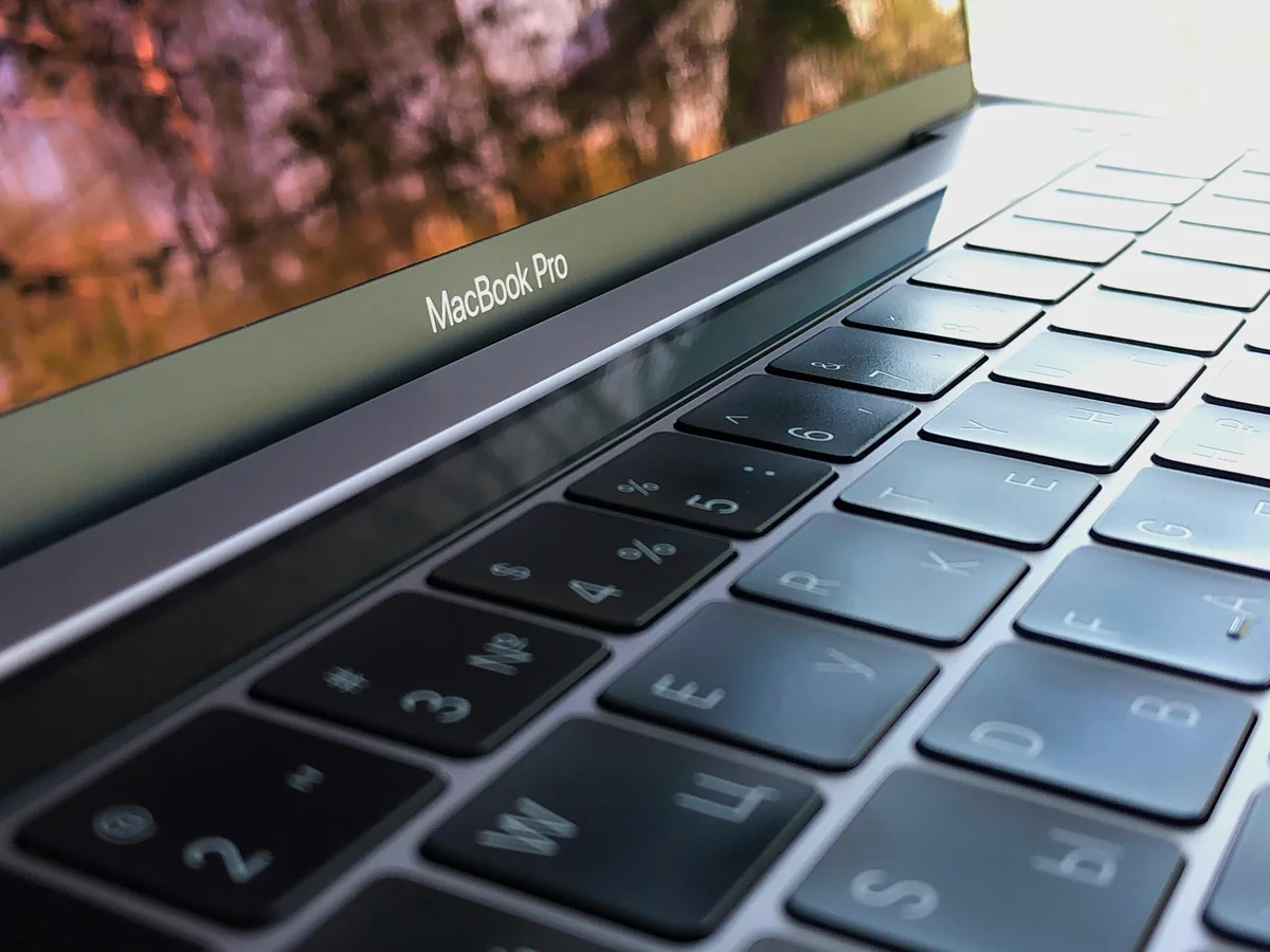 MacBook on a table with a plant — comparing IPTV players on macOS