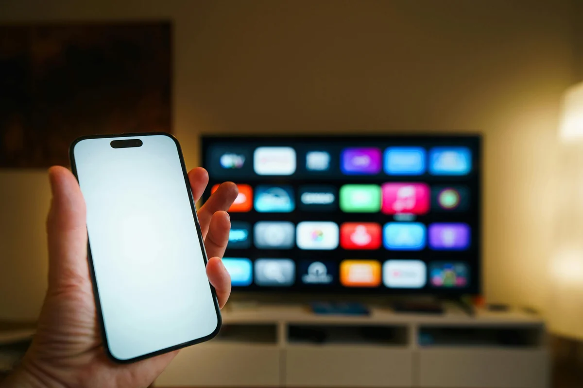 Multiple screens showing IPTV player interface synced across devices — phones, tablet, and smart TV