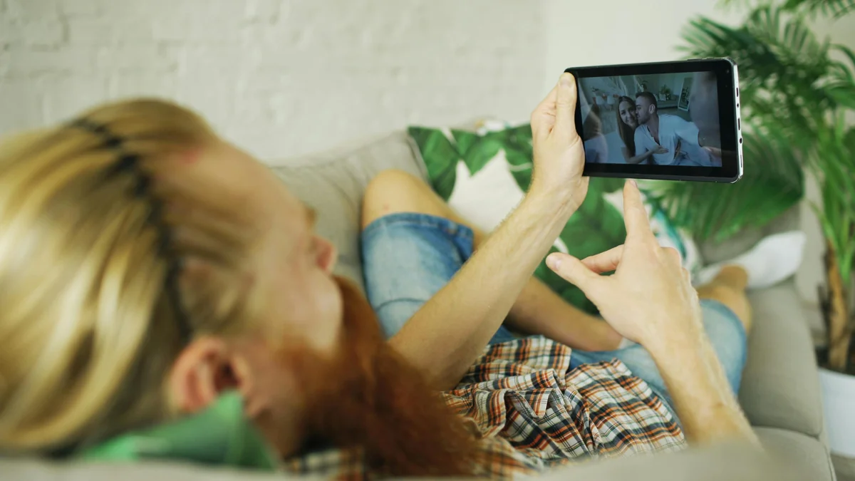 Gezin dat IPTV kijkt op een tablet op de bank