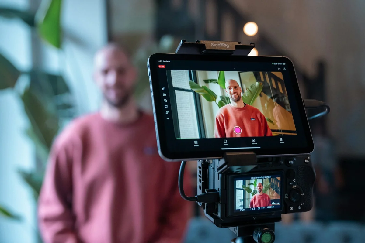 Person holding tablet streaming content — IPTV One syncs your full library across devices