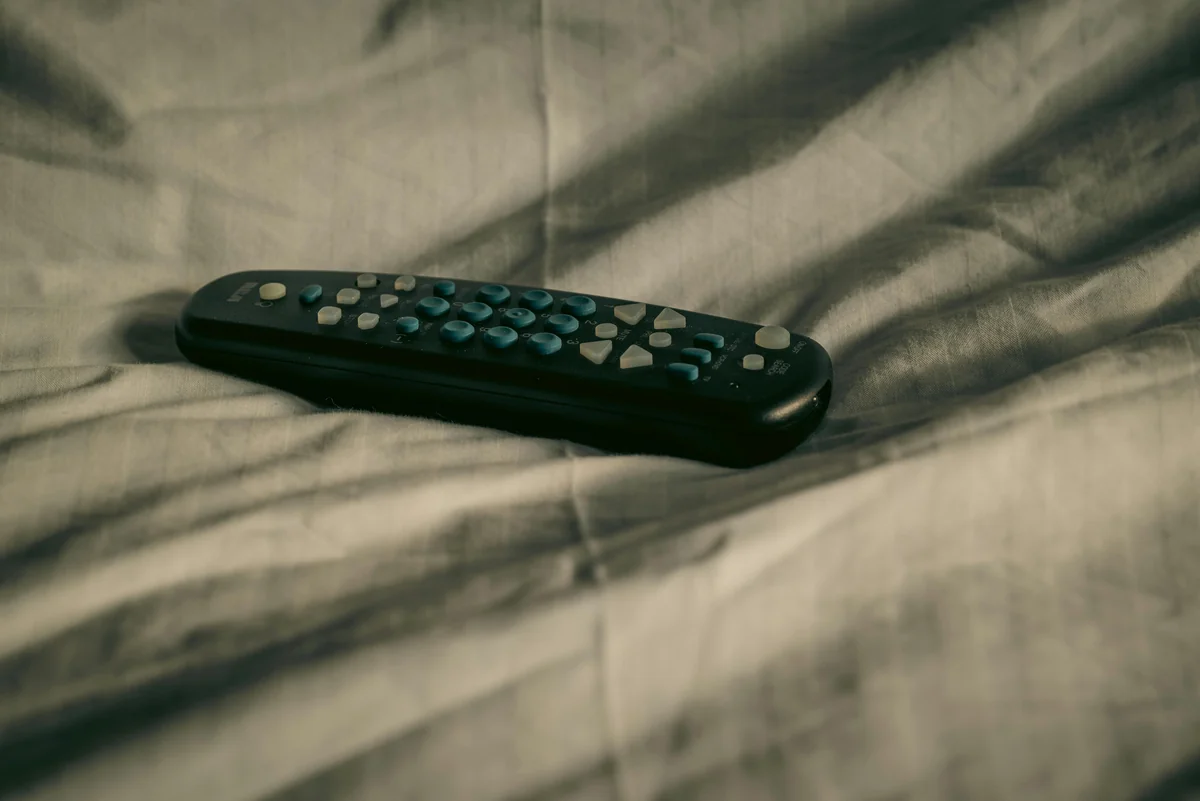 TV remote next to a streaming device showing IPTV playback